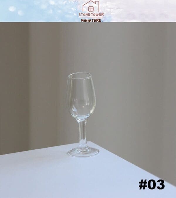 Clear miniature wine glass on a white table with a light gray background, labeled "#03" in the corner.