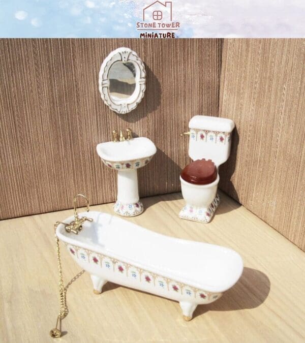 Miniature bathroom set with a bathtub, sink, toilet, and mirror, featuring floral patterns on a wooden surface.