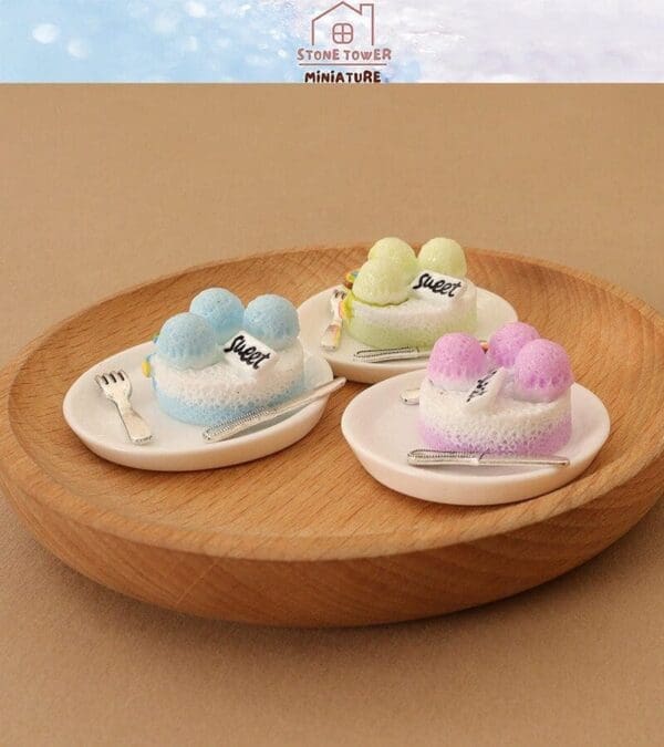 Miniature ice cream cakes in pastel colors on plates with tiny forks, arranged on a wooden tray.