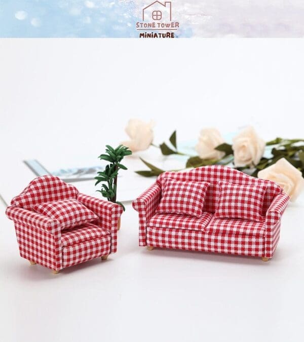 Miniature red gingham armchair and sofa with plants and white roses in the background.