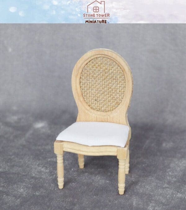 Miniature wooden chair with oval woven back and white cushioned seat on a gray background. Stone Tower Miniature logo above.