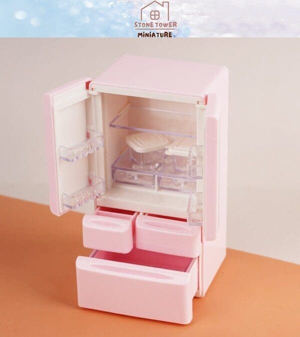 Miniature pink fridge with open doors, showing clear shelves and trays on a peach surface.