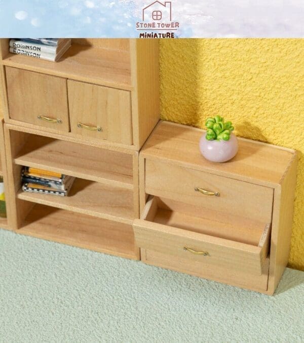 Miniature wooden furniture with open drawers and small books, featuring a tiny potted plant on a textured yellow wall backdrop.