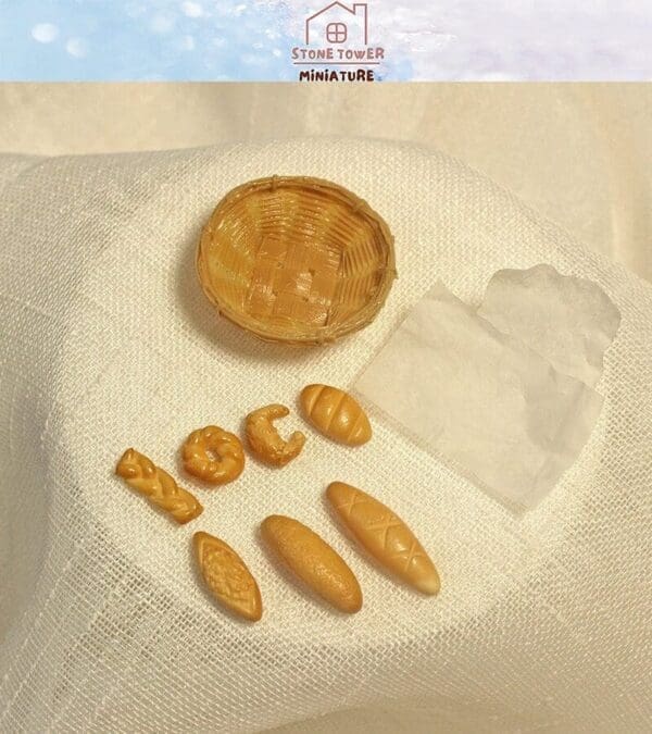 Miniature bread set with basket on white fabric, featuring five types of small bread and a tissue.