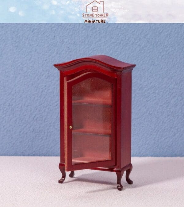 Red mini display cabinet with glass door on blue textured background.