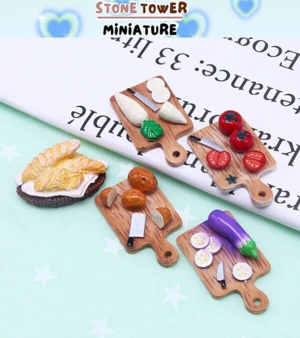 Miniature wooden cutting boards with tiny food items: tomatoes, cheese, eggplant, and bread on a mint green background.