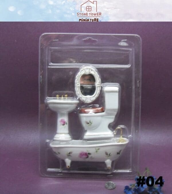 Miniature bathroom set with floral designs in packaging, including a sink, toilet, mirror, and bathtub.