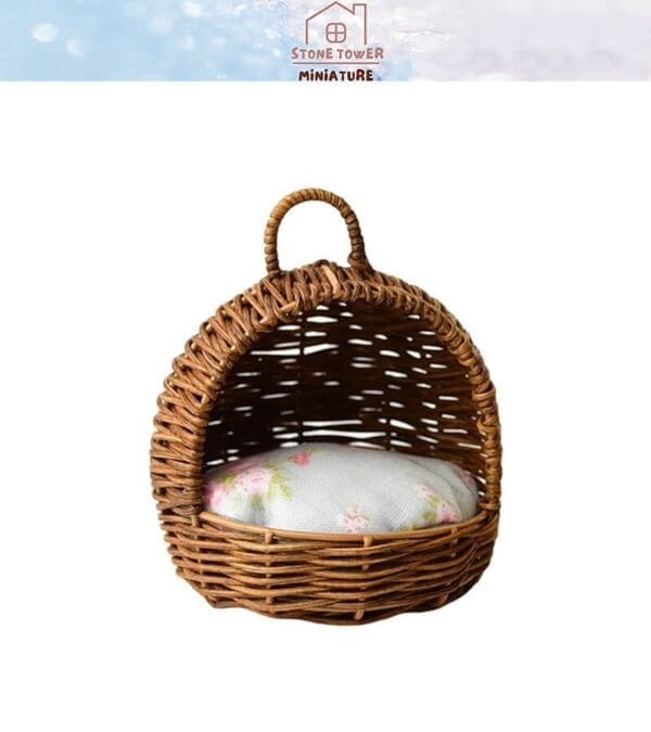 Miniature wicker basket with floral cushion inside, featuring a handle on top.