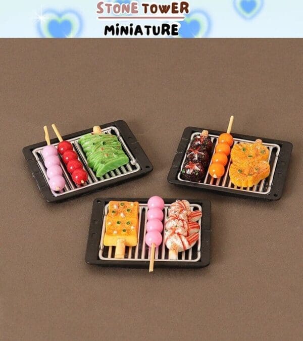 Miniature food skewers on small grills, featuring colorful treats like dango and other snacks, displayed on a brown surface.