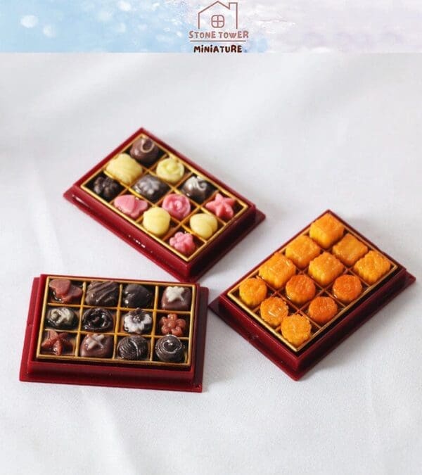 Three trays of miniature assorted sweets on a white surface, each tray featuring different colors and shapes.