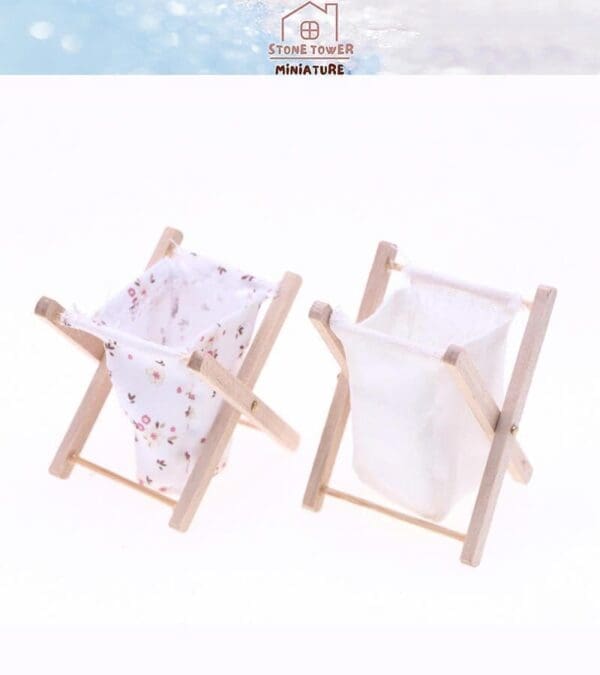 Two miniature laundry hampers with wooden frames, one with floral fabric, the other plain white, on a light background.