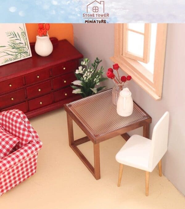 Miniature room with red dresser, white chair, table, and vase. Decor includes red flowers and a plant picture.