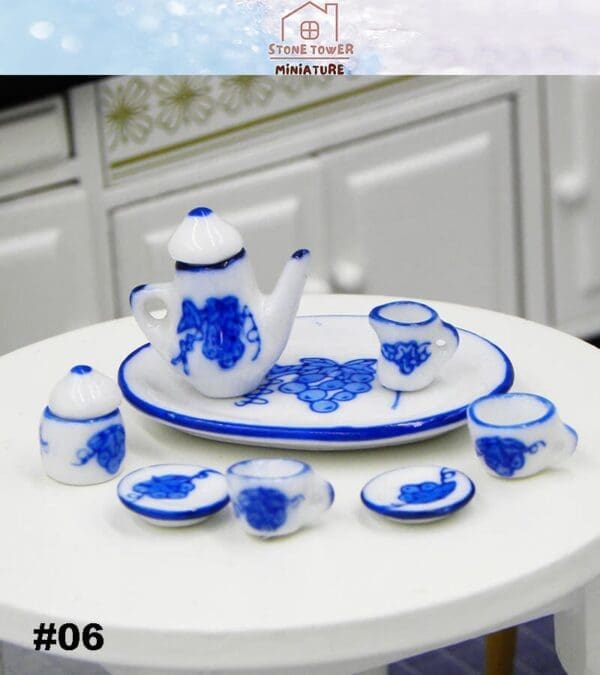 Miniature blue and white porcelain tea set with intricate designs, displayed on a small round table.