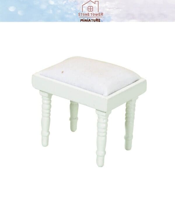 White miniature stool with cushioned top and detailed legs, displayed on a light background.