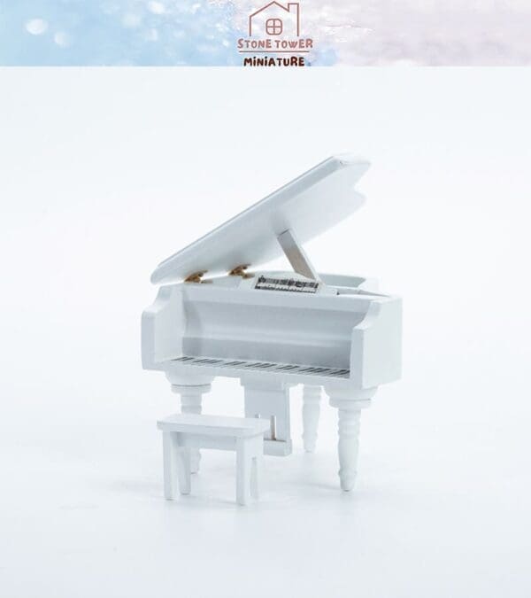 White miniature grand piano with matching bench on a plain background.