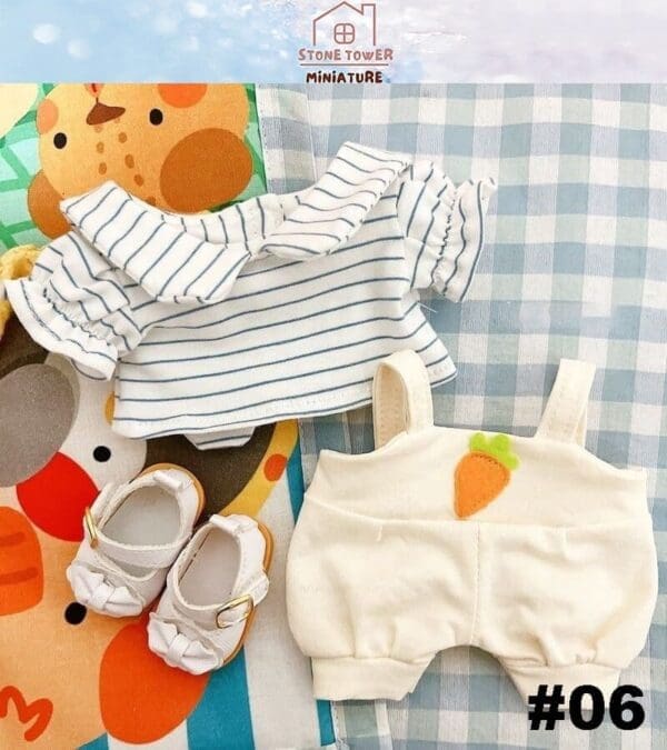 Striped blouse, white overalls with carrot patch, and white sandals on a colorful mat with geometric designs.