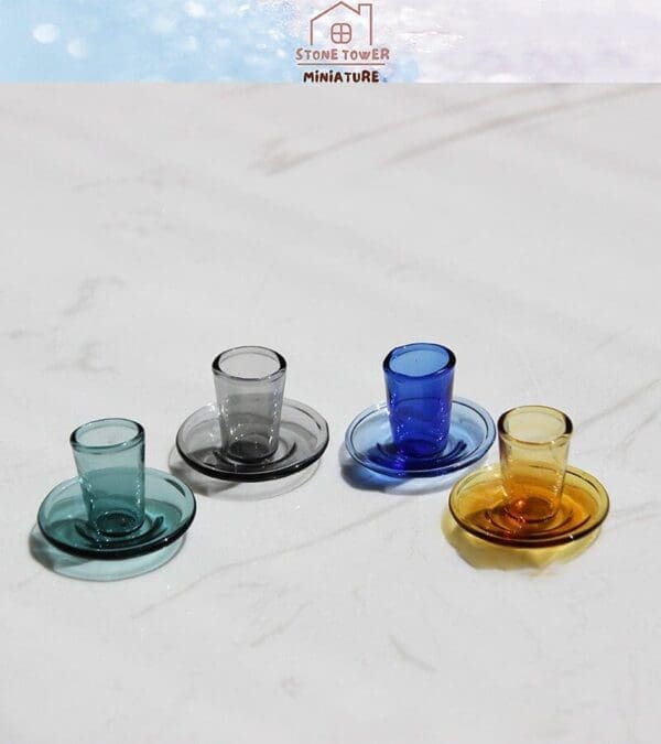 Colorful miniature glass tea sets on a white marble surface.