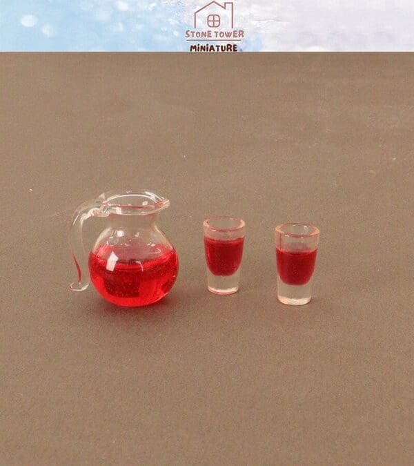 Miniature clear jug and two small glasses filled with red liquid on a brown surface.