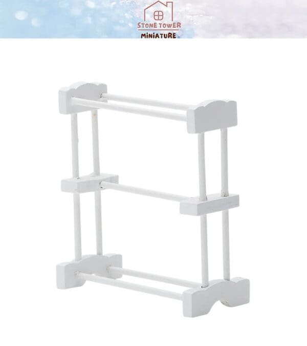 White miniature wooden drying rack with three levels against a plain background.