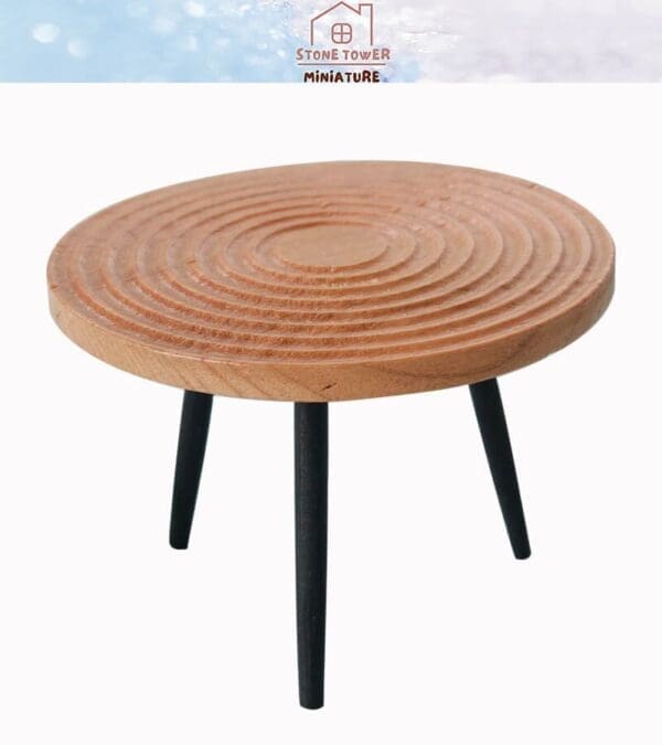 Round wooden miniature table with a spiral pattern and black metal legs.