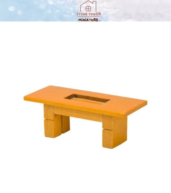 Miniature orange wooden table with a rectangular cutout in the center, displayed on a white background.