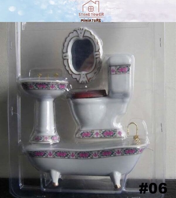 Miniature porcelain bathroom set with floral designs, including a toilet, sink, bathtub, and mirror in packaging.