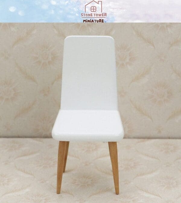 White miniature chair with wooden legs on a patterned beige background, under a light blue sky with a logo.