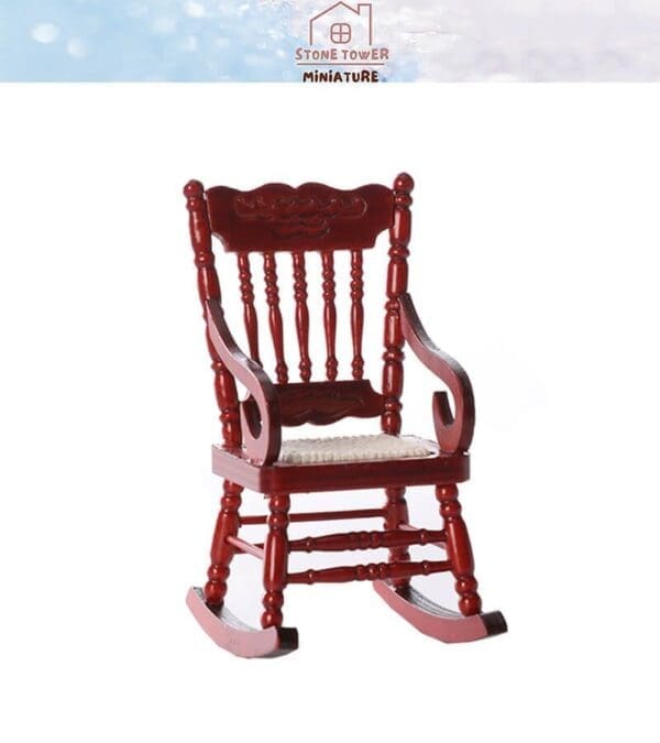 Miniature red wooden rocking chair with detailed backrest and seat cushion, isolated on a white background.