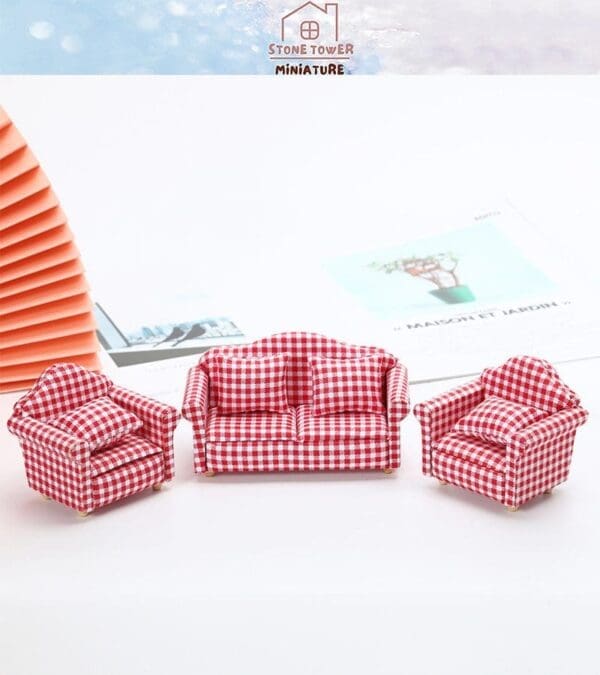 Miniature red and white checkered living room set with a sofa and two armchairs on a white surface.