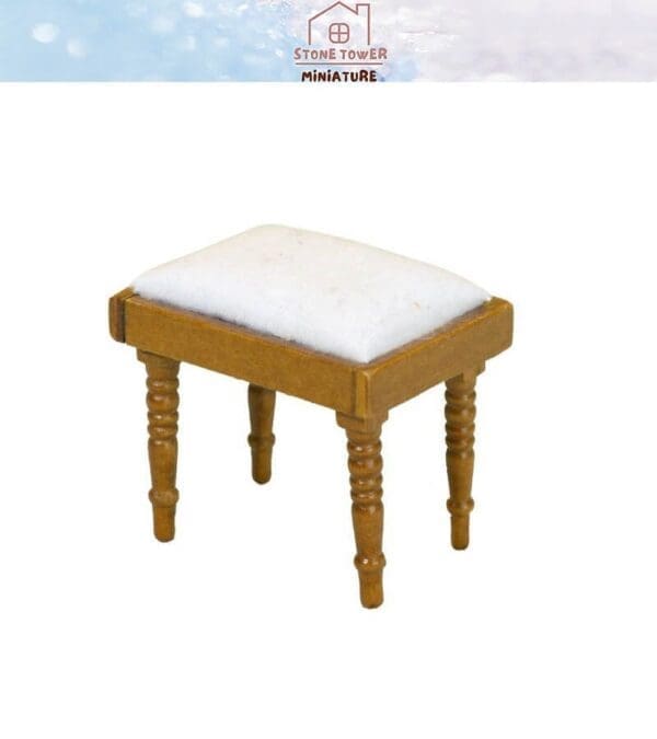 Miniature wooden stool with turned legs and a white cushioned seat.