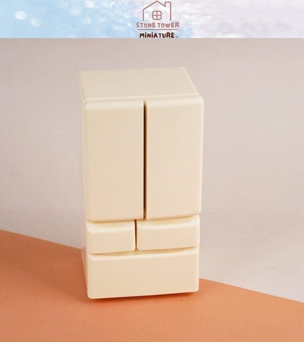 Miniature refrigerator model in cream color on a peach surface with "Stone Tower Miniature" label above.