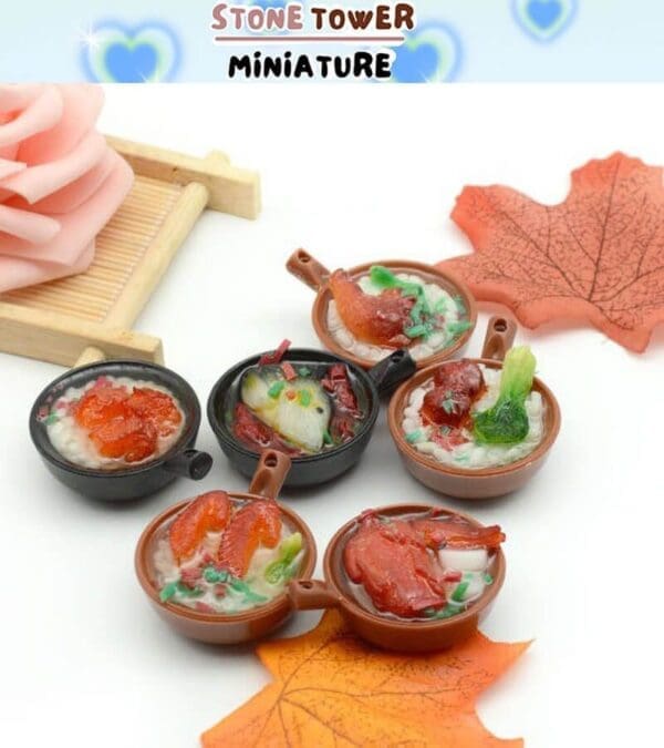 Miniature bowls of colorful soup displayed on a table with decorative leaves and a pink flower in the background.