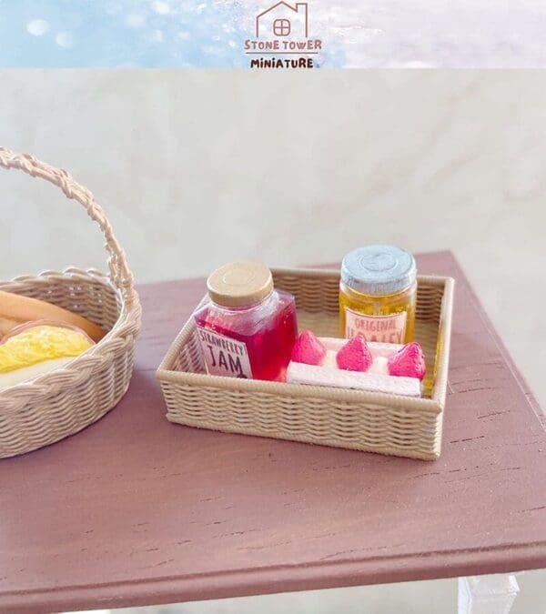 Miniature basket with jars of strawberry jam and honey next to bread and pastries on a wooden table.