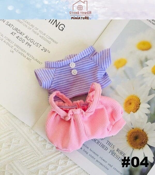 Miniature striped shirt and pink skirt on a daisy-themed magazine page.