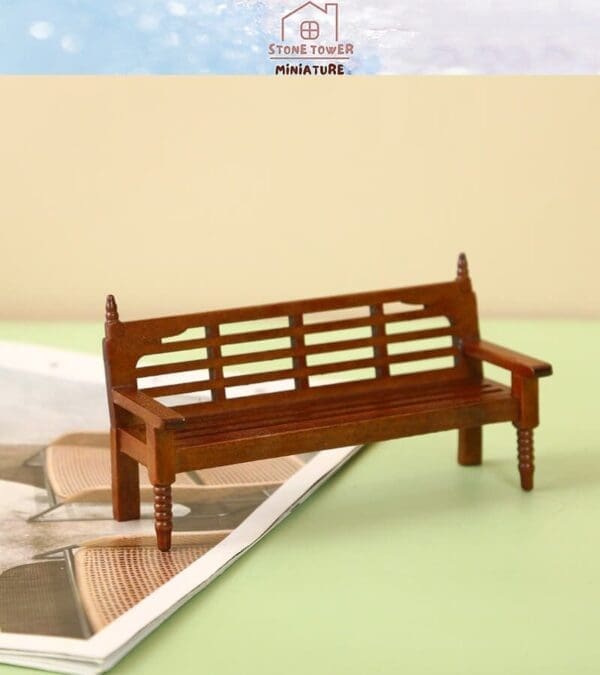 Miniature wooden bench displayed on an open magazine with a light background.