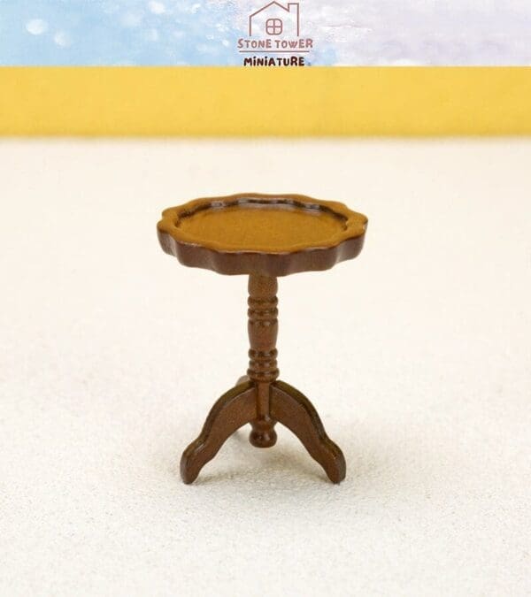 Miniature brown wooden pedestal table with a scalloped edge top, set on a light background.