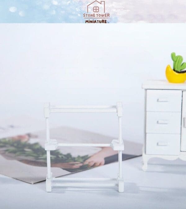 Miniature white rack and white dresser with a yellow cactus pot on top, set against a soft blue and white background.