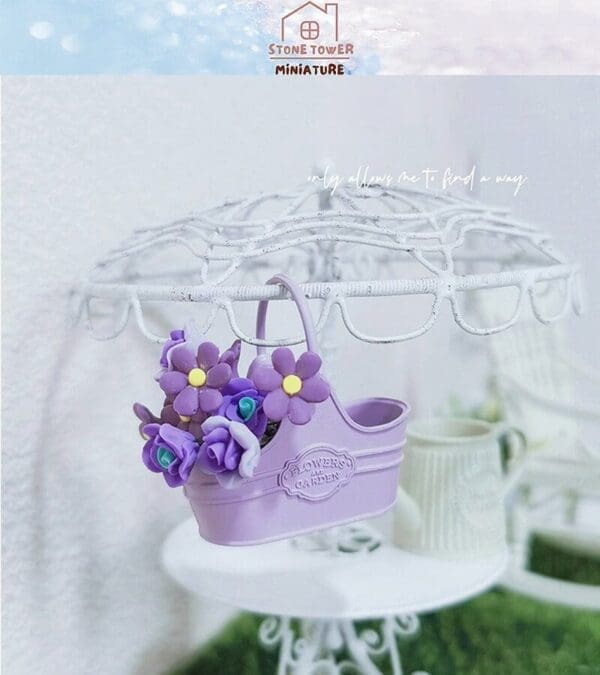 Purple flower basket with miniature blooms on a decorative white shelf, labeled "FLOWER GARDEN.