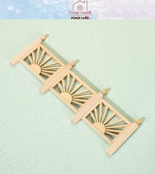 Wooden miniature fence with sunrise design on a light green background.