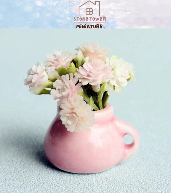 Miniature pink vase with delicate white flowers against a light blue background.