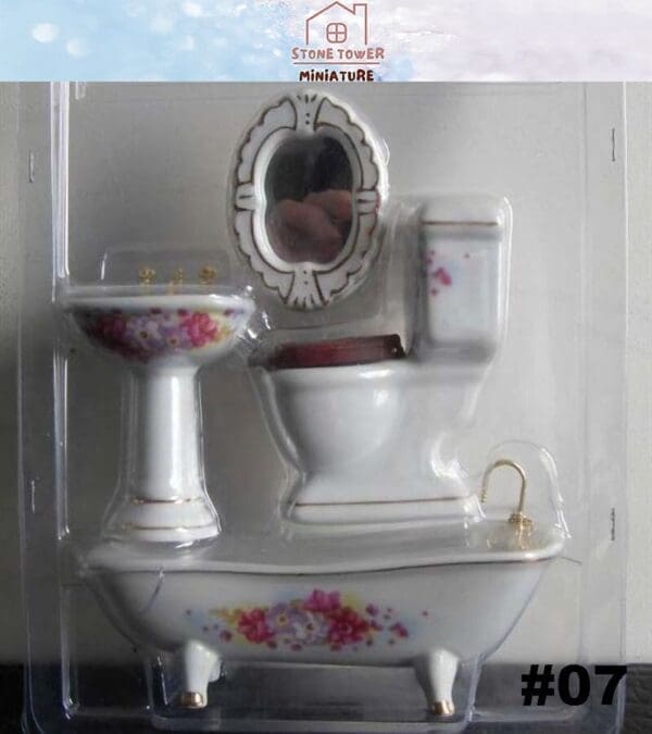 Miniature porcelain bathroom set with floral designs, including a sink, bathtub, toilet, and mirror in packaging.