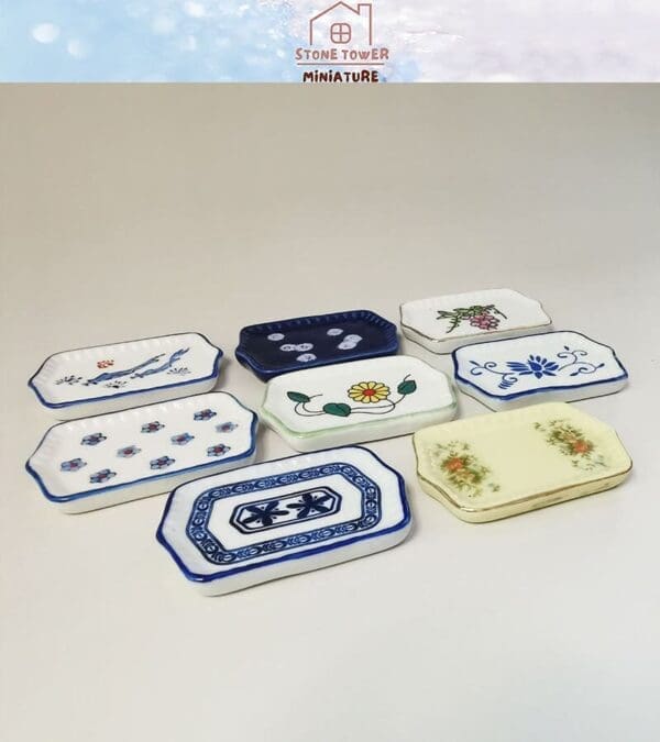 Set of decorative miniature plates with various floral and geometric patterns on a white background.