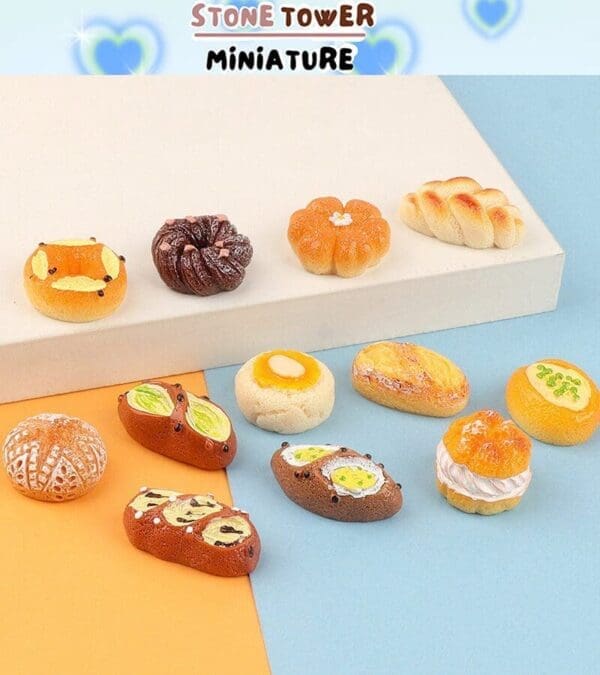 Miniature bread models displayed on a two-tone surface, showcasing various shapes and toppings.