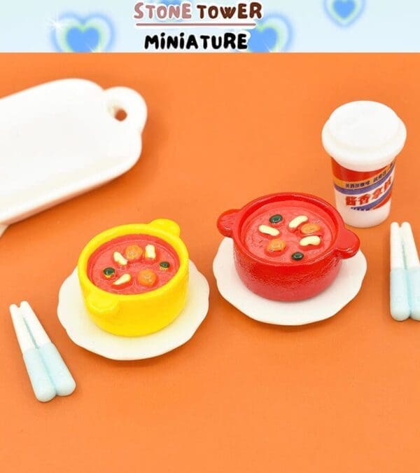 Miniature yellow and red soup pots with chopsticks and a small drink cup on an orange background.