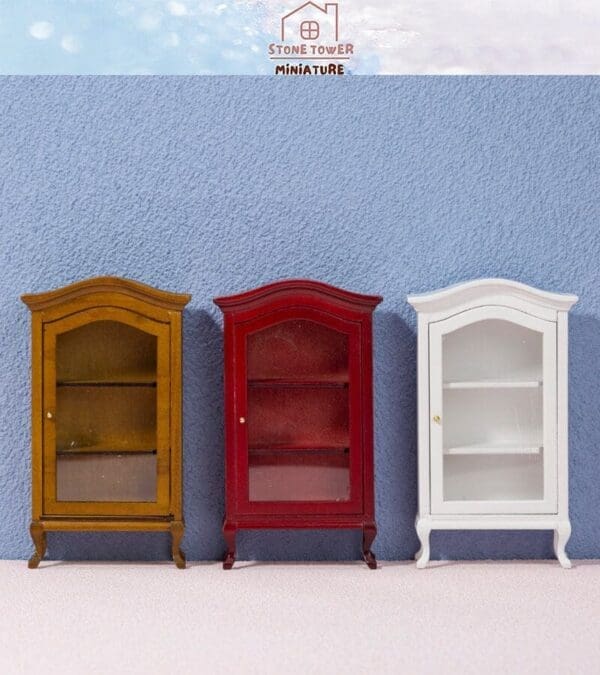 Three miniature wooden cabinets, brown, red, and white, against a blue background.