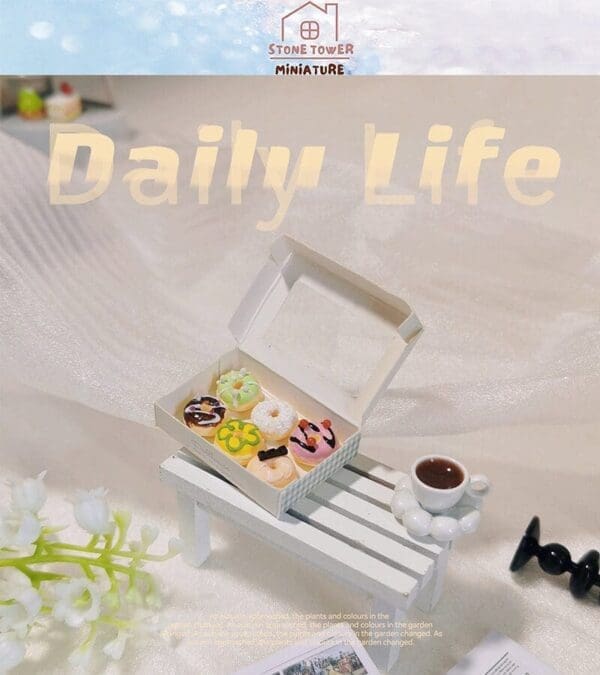 Miniature donuts in a box on a small white bench with a cup of coffee and decorative flowers nearby.