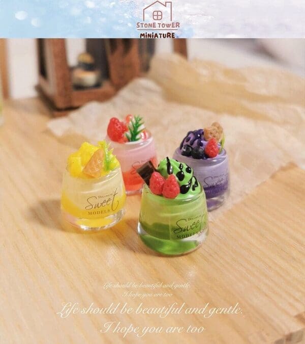 Miniature dessert models with fruit toppings on a wooden surface. Text reads, "Life should be beautiful and gentle.