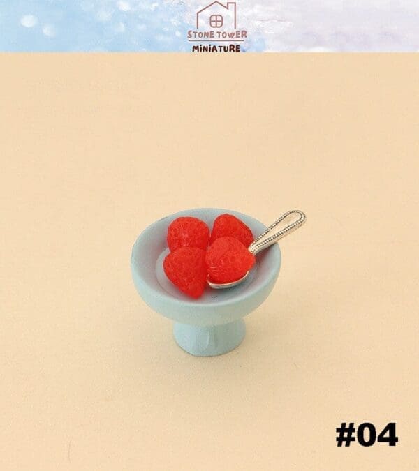 Miniature strawberries in a light blue dish with a tiny spoon on a beige background, labeled #04.