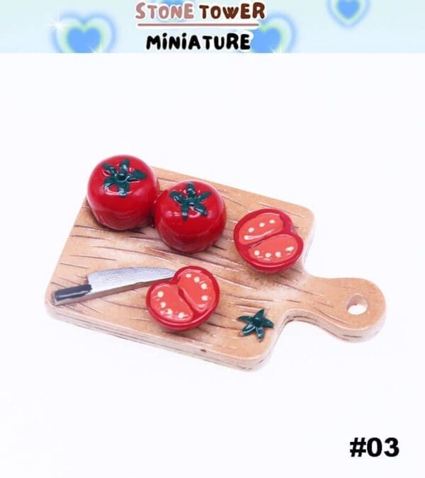 Miniature cutting board with whole and sliced tomatoes, a small knife, and tomato leaves.