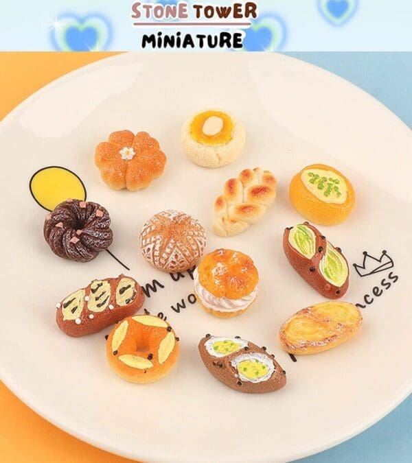 Miniature assorted bread and pastries displayed on a white plate with decorative text and designs.